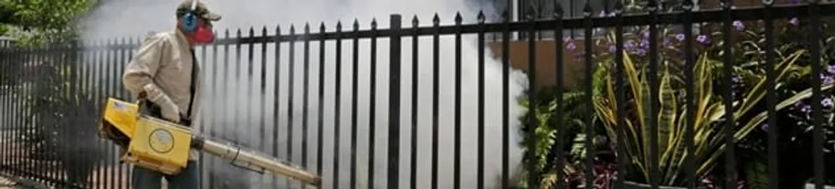 Mosquito control technician fogging a yard perimeter for mosquito reduction in Peoria, IL